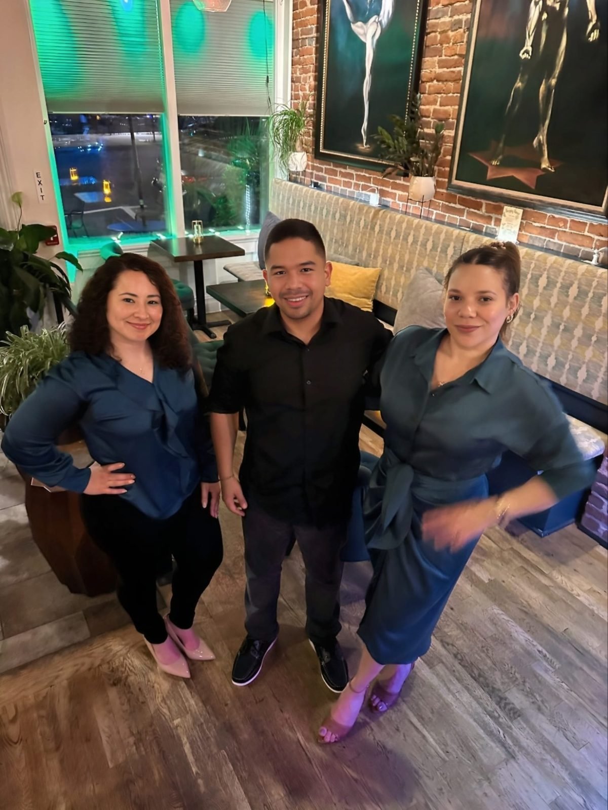 Tres emprendedores posando juntos en el salón del evento