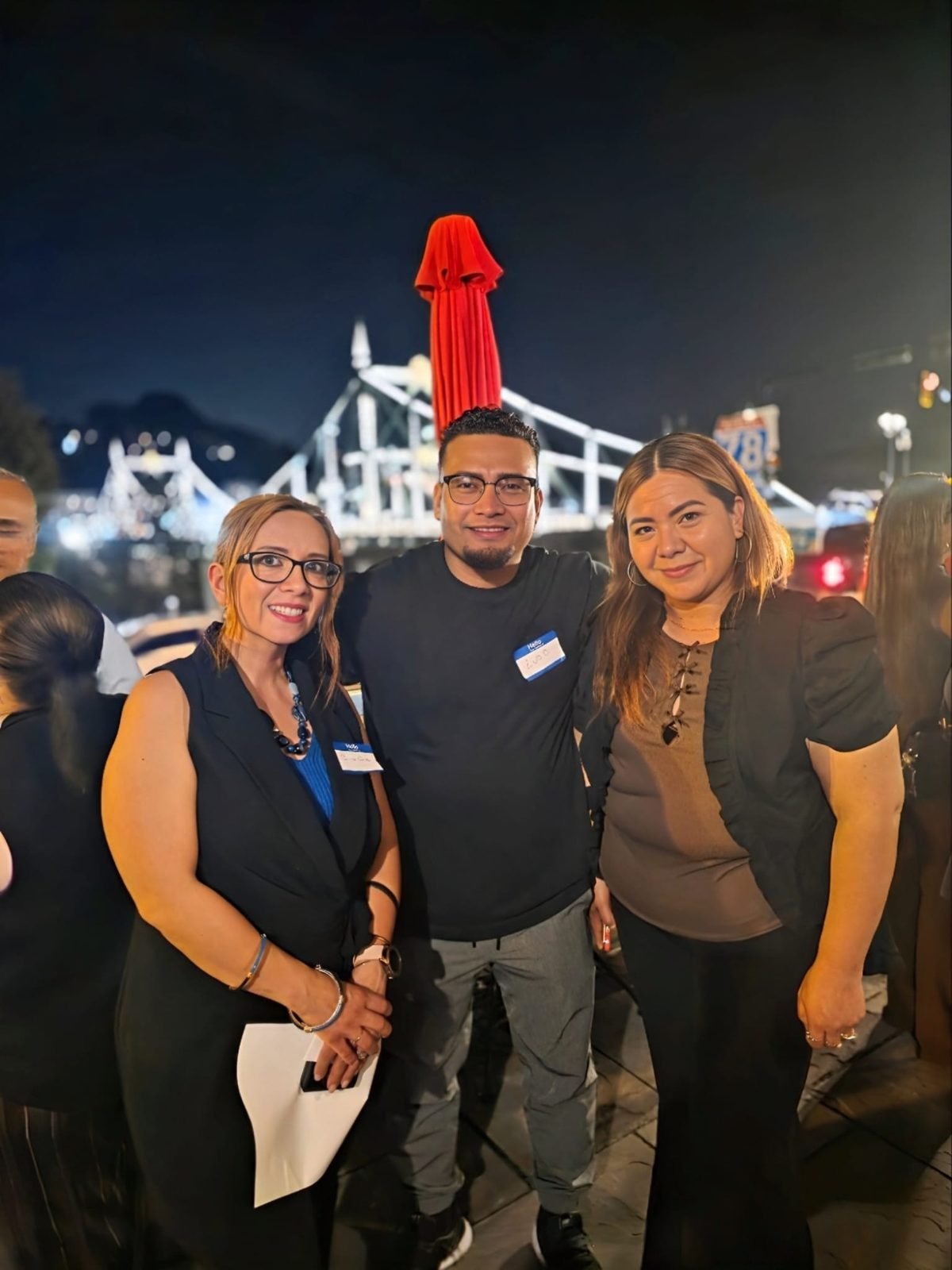 Tres emprendedores posando juntos con el puente de fondo
